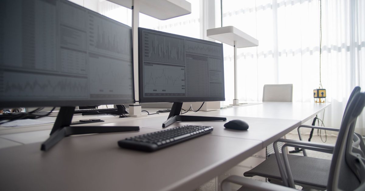 two external monitors side by side on a bright office desk with a keyboard